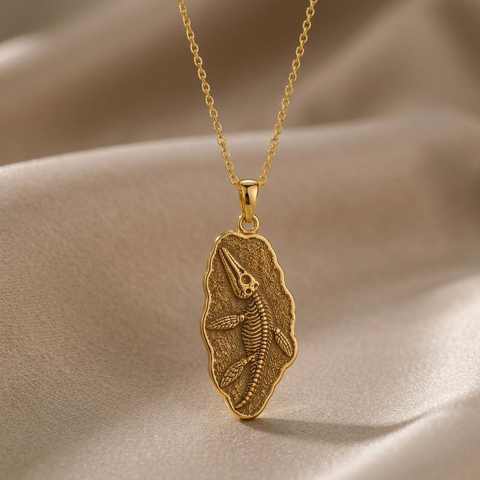 Gold Plated Silver Liopleurodon Fossil Pendant Necklace with raised skeleton relief on draped neutral fabric