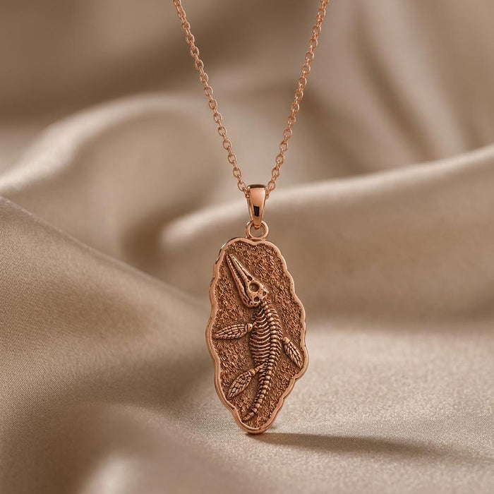 Rose Gold Plated Liopleurodon Fossil Pendant Necklace close-up on folded neutral fabric