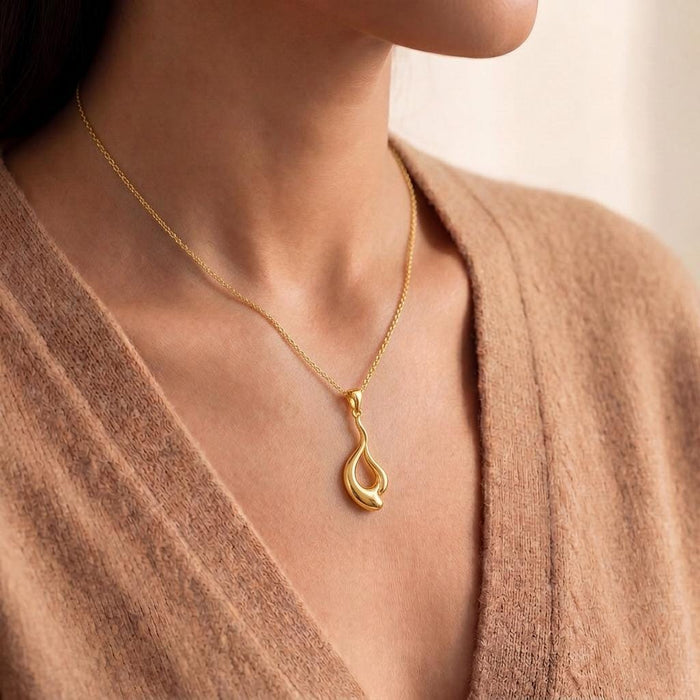Side neckline view of the gold-tone Liquid Flow pendant
