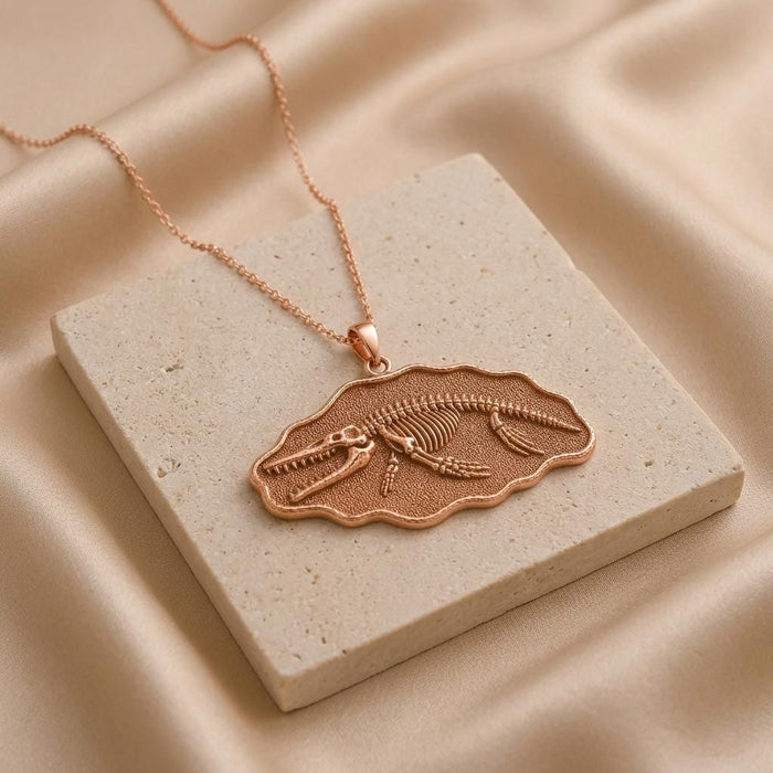 Rose Gold Plated Livyatan Fossil Pendant Necklace displayed on a pale stone block