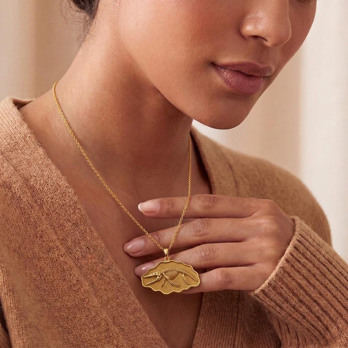 Gold Plated Silver Livyatan Fossil Pendant Necklace worn with a knit top and held at the pendant