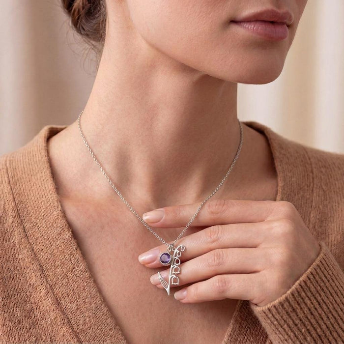 Silver May Birth Flower Necklace with a round purple stone accent worn with a warm neutral sweater