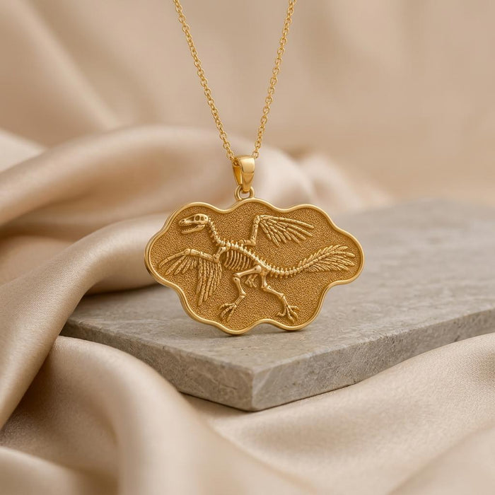 Gold Plated Silver Microraptor fossil pendant with a winged skeleton relief on a stone slab