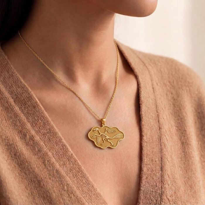 Model wearing a Gold Plated Silver Microraptor fossil pendant necklace at the collarbone