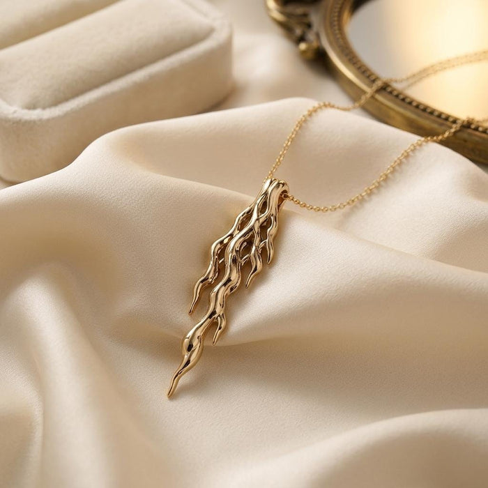 Gold Plated Silver Molten Vein Pendant Necklace on ivory satin beside a mirror and jewelry box