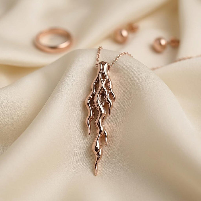Rose Gold Plated Molten Vein Pendant Necklace with tapered openwork lines on draped ivory fabric