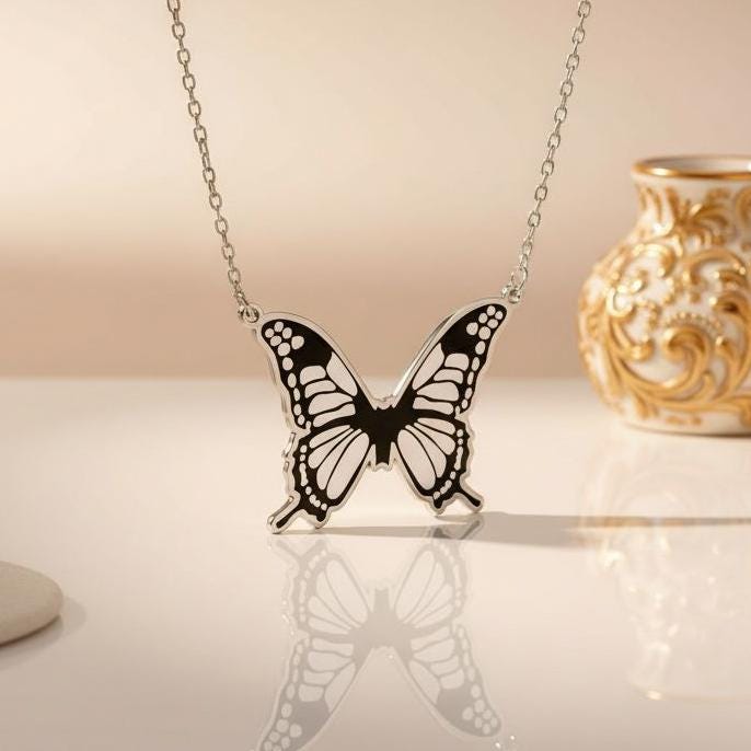 Front product view of the Monarch Butterfly Necklace with a reflected pendant