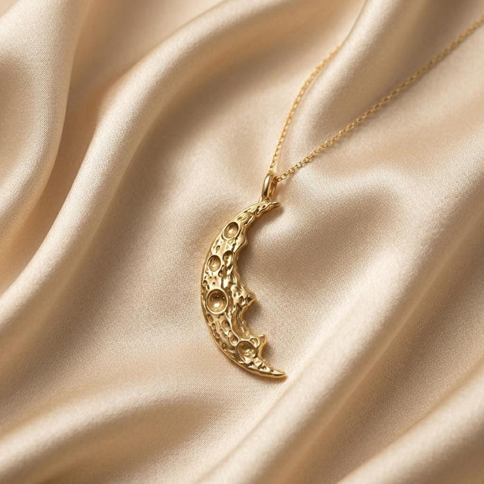 Gold Plated Silver Moon Fragment Pendant Necklace with raised circular crater details on champagne satin