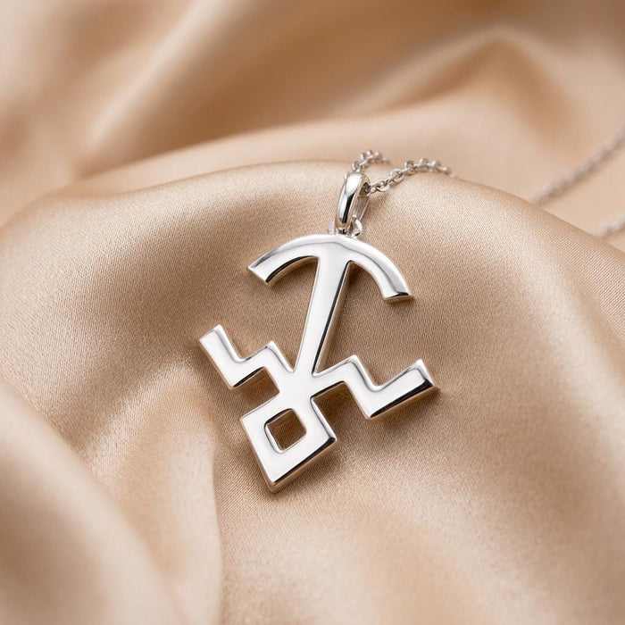 Close-up of the Mula symbol pendant showing its curved top bar and open diamond-shaped base