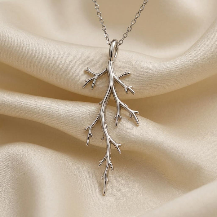 Silver Mystic Forest Branch Pendant Necklace arranged on folded ivory satin
