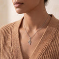 Nibiru Symbol Necklace worn at the collarbone with a tan knit cardigan