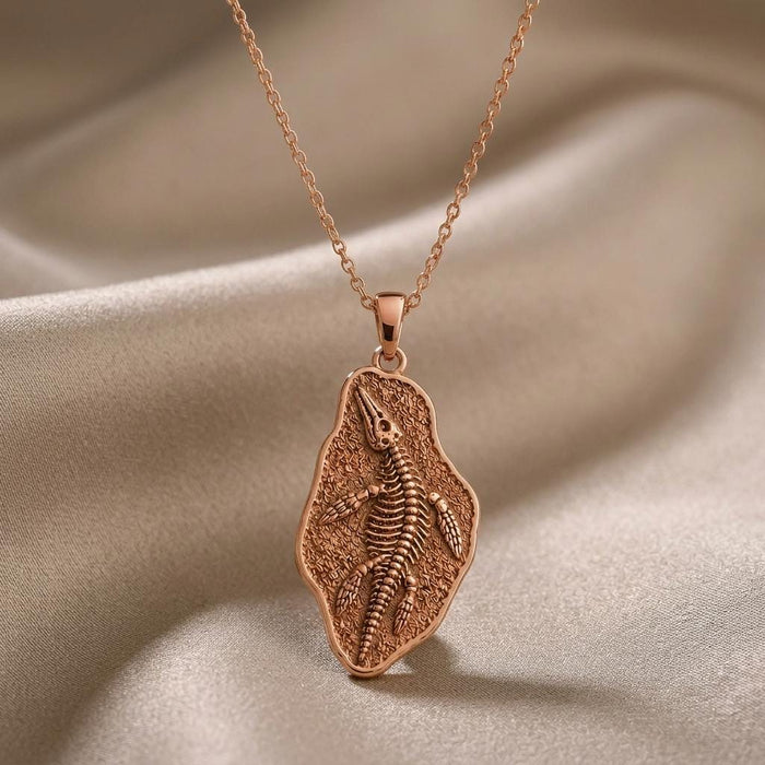 Rose Gold Plated Nothosaurus Fossil Pendant Necklace displayed on draped beige fabric