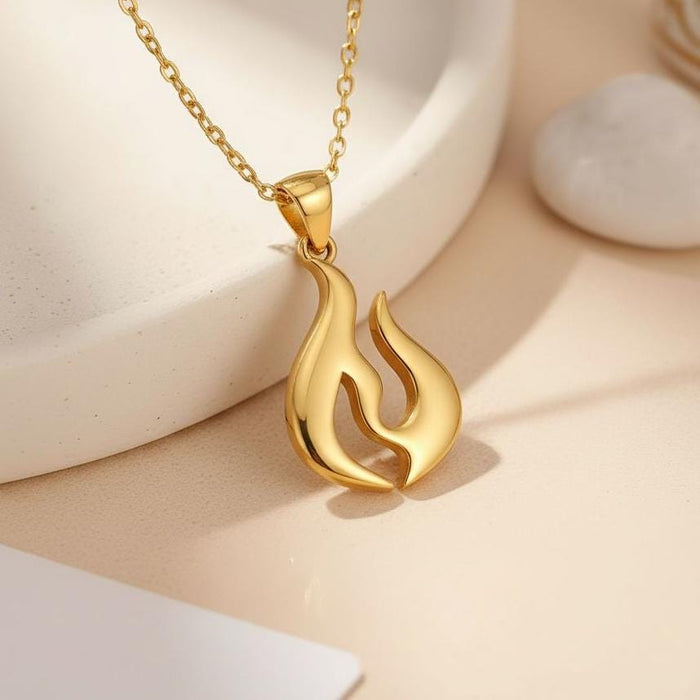 Gold Plated Silver Flame Energy Symbol Necklace displayed beside a white ceramic object