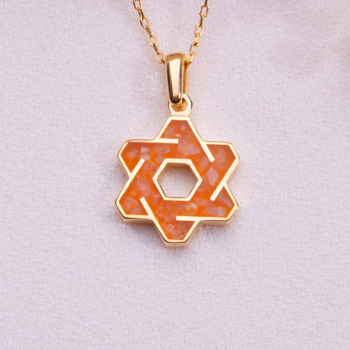 Orange agate interlaced six-point star pendant necklace with an open hexagonal center on pale fabric