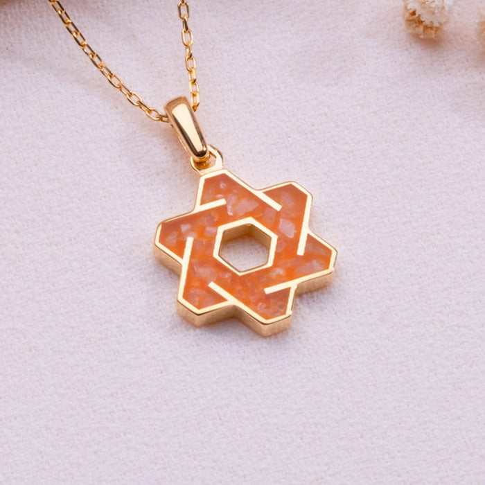 Angled close-up of orange agate interlaced six-point star pendant with open hexagonal center