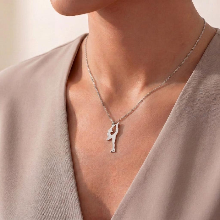 Figure Skater Necklace with an overhead skate-hold pendant worn with a beige V-neck blouse