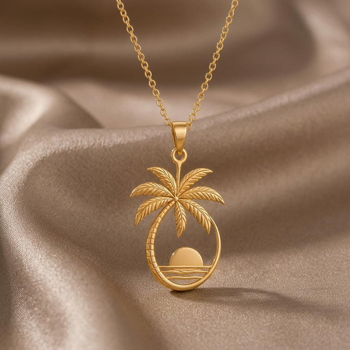 Gold Plated Silver Palm Sunset Pendant Necklace with textured palm fronds, a sun, and layered waves on champagne satin
