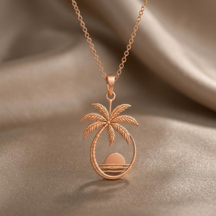 Rose-tone Palm Sunset pendant necklace displayed on champagne satin