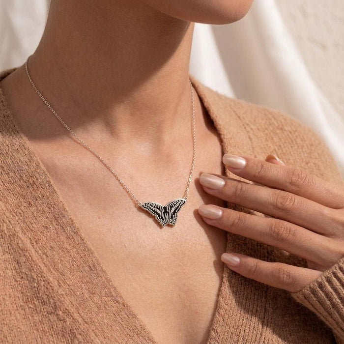 Patterned Butterfly Necklace worn with a textured neutral cardigan