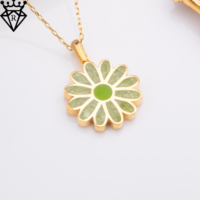 Angled close-up of the green-petal daisy pendant on a gold-toned chain against a white background, catalog view 2