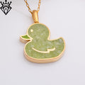 Front close-up of a gold-tone duck pendant with pale green textured detail on a white background