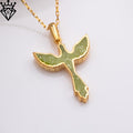 Angled close-up of the green phoenix pendant on a gold-tone chain, showing the raised edge and scalloped wing shape