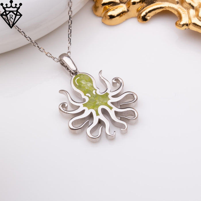 Angled close-up of the octopus pendant on a light styled background