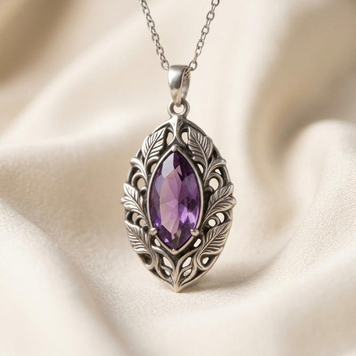 Personalized Elven Amethyst Necklace with a faceted violet marquise-shaped center stone in a leaf-detailed openwork frame on cream fabric