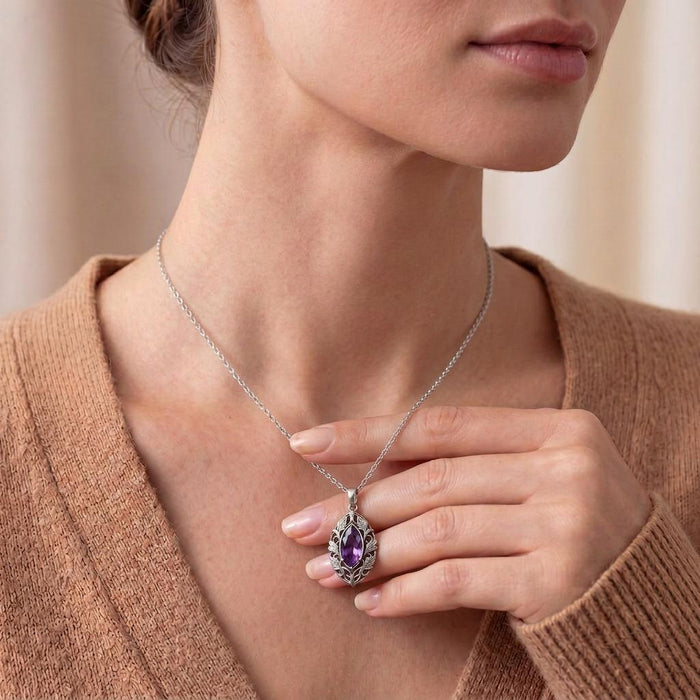 Close view of a model wearing the leaf-framed violet marquise pendant at the collarbone