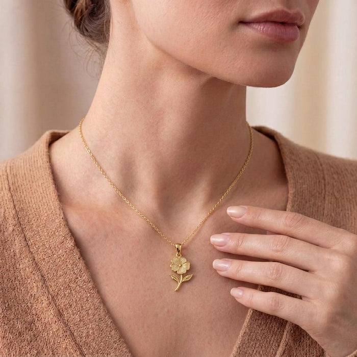 Gold Plated Silver phlox flower necklace worn near the collarbone with a knit top
