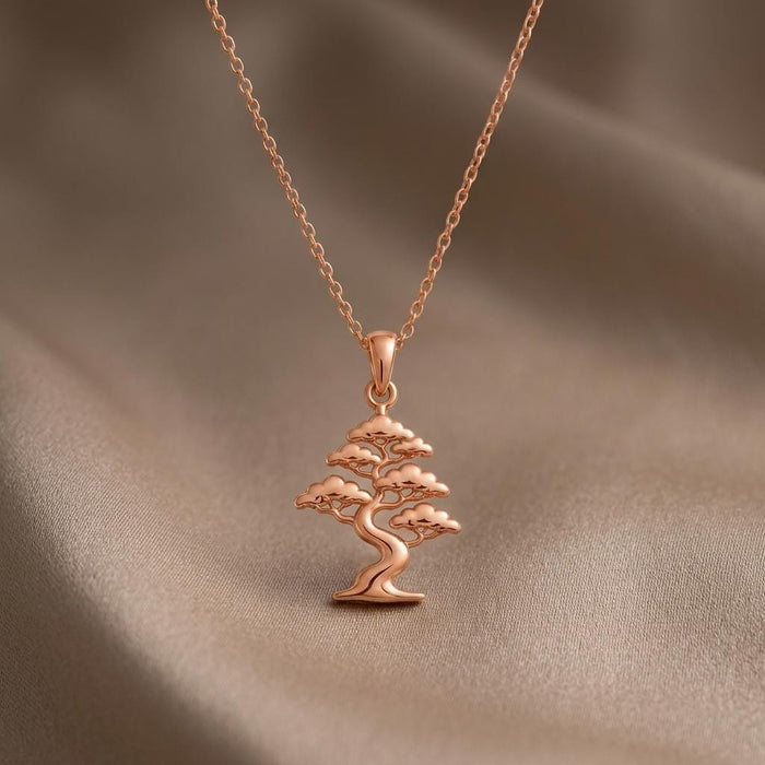 Rose Gold Plated Pine Crest Bonsai Pendant necklace with winding trunk on taupe fabric