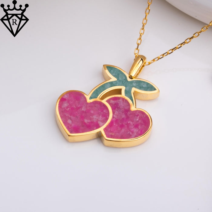 Close product image of a pink agate double-cherry pendant with green leaf detail