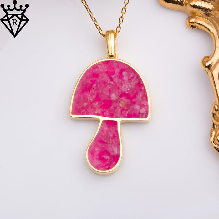 Pink agate mushroom pendant displayed beside an ornate frame