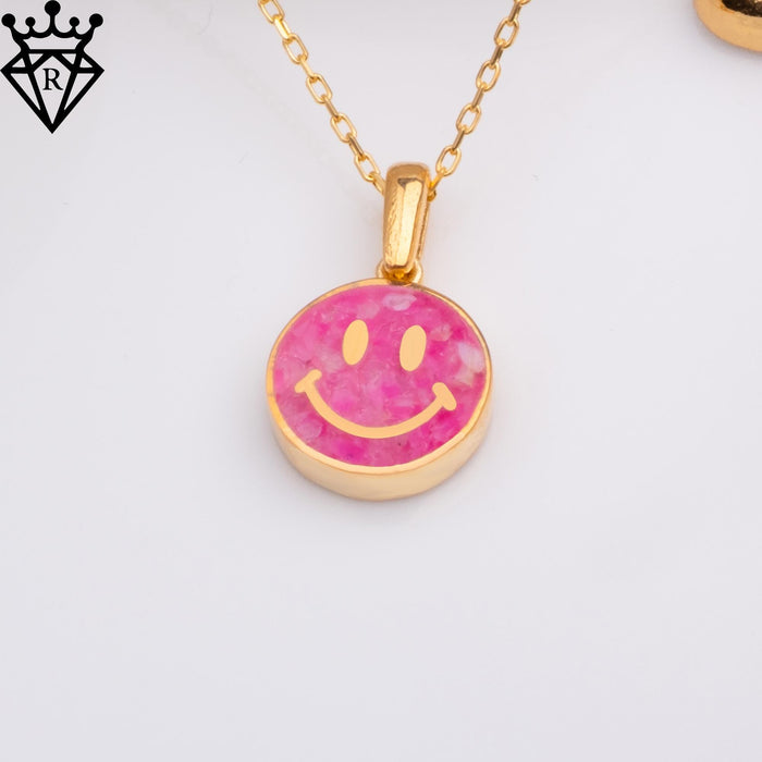 Front view of the round pink smiley charm and polished facial details