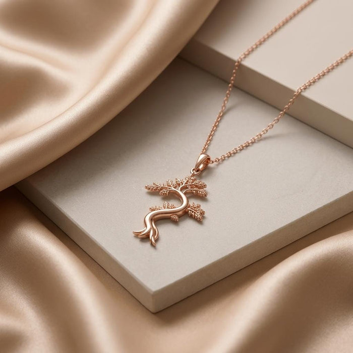 Rose Gold Plated Juniper Flame Pendant Necklace displayed on a cream block with satin fabric