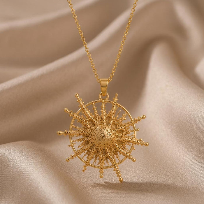 Gold Plated Silver Pollux Star Pendant Necklace with rounded radiating rays inside a circular frame on beige fabric