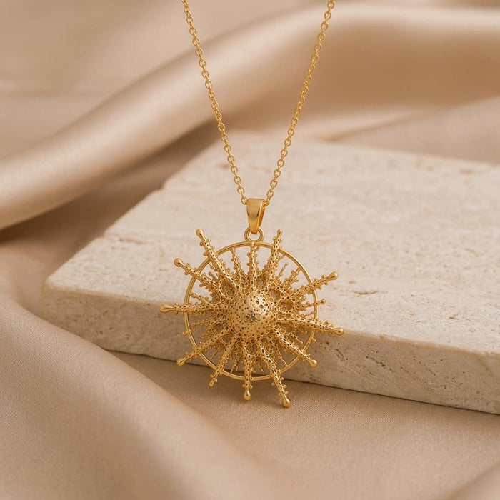 Gold Plated Silver Pollux Star Pendant Necklace displayed on a pale stone block with beige fabric
