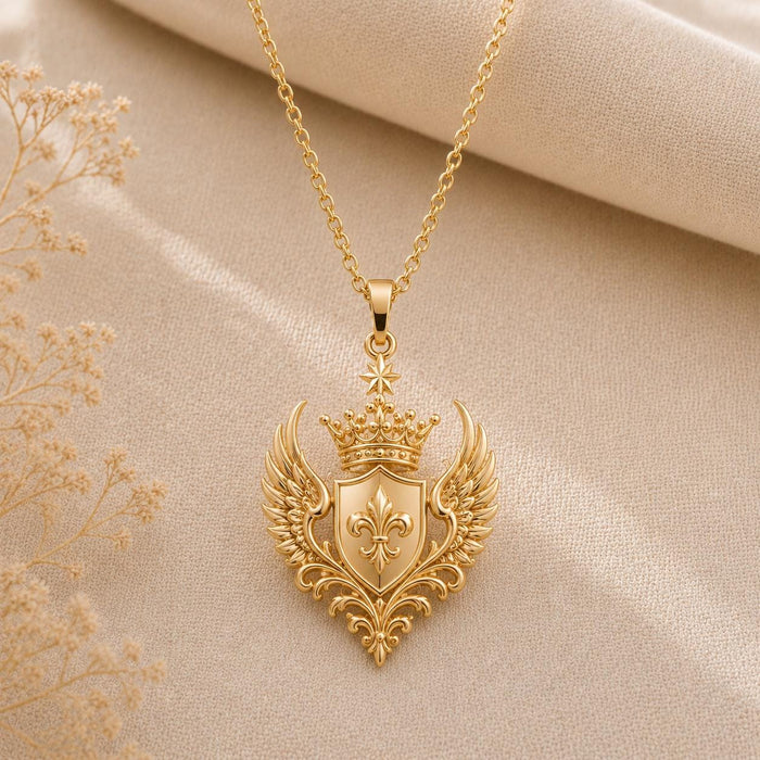 Gold Plated Silver Queen Seraph Crest Pendant with a crowned shield and feathered wings on beige fabric
