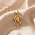 Gold Plated Silver Rose Flower Pendant Necklace with a layered spiral-petal rose bloom, curved stem, and textured leaf on champagne satin