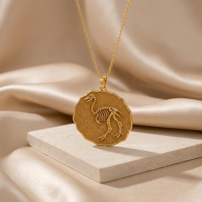 Gold Plated Silver Aepyornis fossil medallion necklace displayed on a pale stone block and satin
