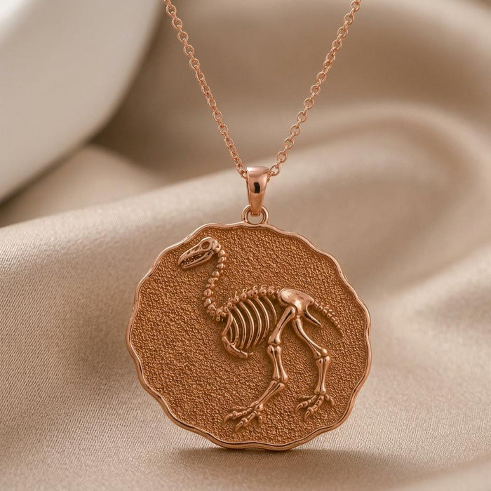 Rose Gold Plated Aepyornis Fossil Pendant Necklace with skeletal bird relief on neutral satin
