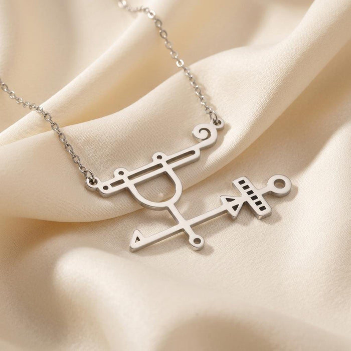 Silver Sabnock sigil pendant necklace displayed on folded ivory fabric