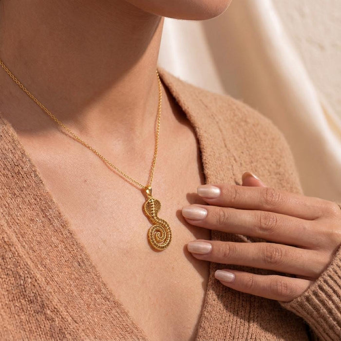 Close neckline view of a model wearing the Gold Plated Silver Sacred Cobra Fossil Necklace