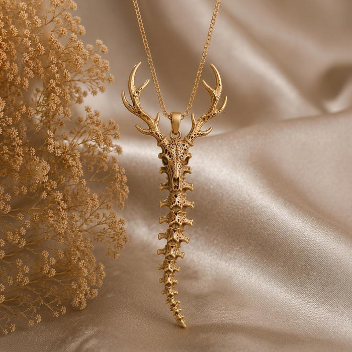 Gold Plated Silver Sacred Deer Spine Necklace with branching antlers, deer skull, and tapered vertebrae pendant on champagne satin