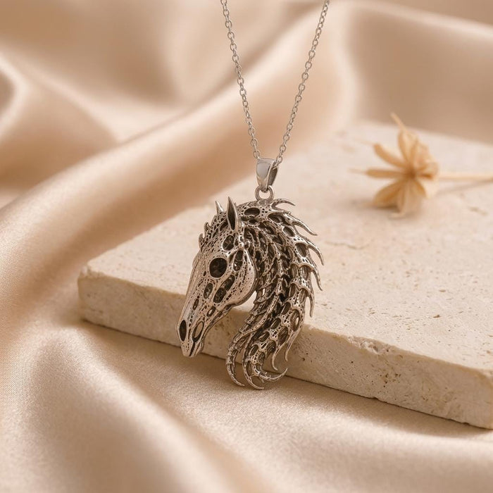 Silver Sacred Horse Skull Relic pendant with open eye and nasal details beside a pale stone block