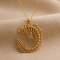 Gold Plated Silver Sacred Koi Relic pendant necklace with a curled openwork koi silhouette on beige fabric