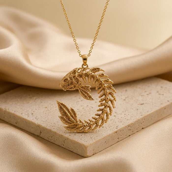 Gold Plated Silver Sacred Koi Relic pendant necklace displayed on a stone slab with draped satin