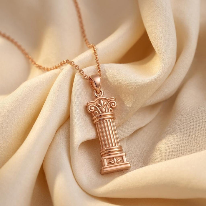Rose-tone Sacred Pillar Necklace with fluted column pendant displayed on folded ivory fabric