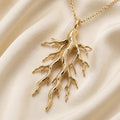 Gold Plated Silver Sacred Root Necklace with branching root pendant on cream satin