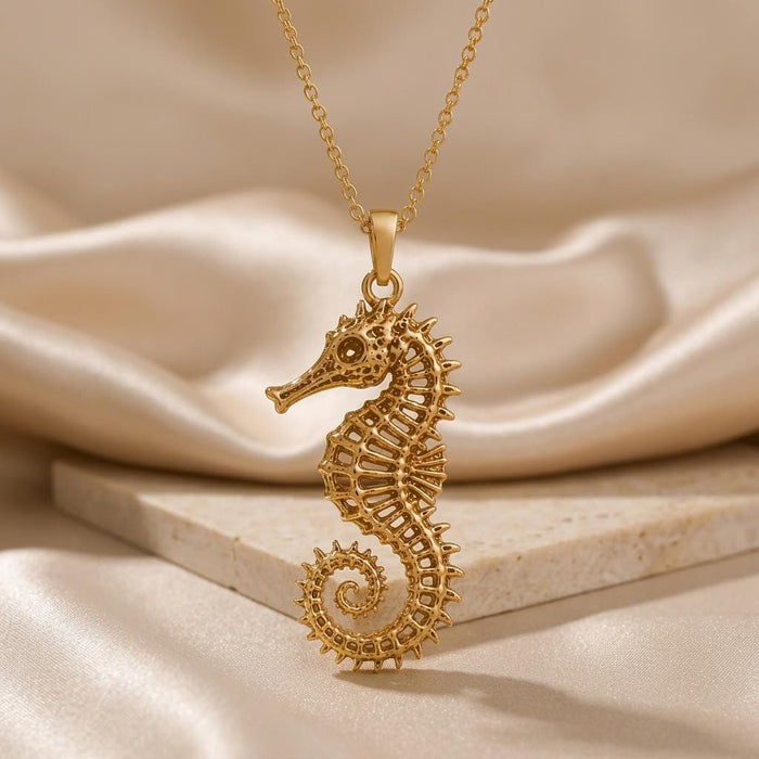 Front view of Gold Plated Silver openwork Sacred Seahorse Pendant Necklace on a stone display